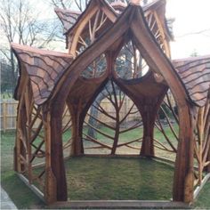 a wooden gazebo in the middle of a yard