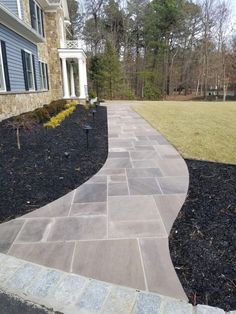 a stone walkway in front of a house