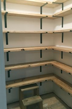 an empty room with shelves and benches in the corner, all made out of plywood