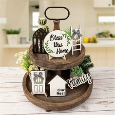 three tiered wooden tray with signs and decorations on the top that says, bless this home