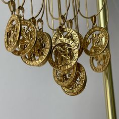 several gold necklaces hanging from a metal pole