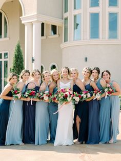 a group of women standing next to each other in front of a building