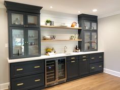 a kitchen with gray cabinets and white counter tops, wood flooring and open shelving