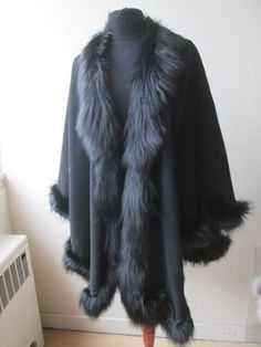 MODA  FURS FABULOUS FUR FASHIONS AT UNBEATABLE PRICES   Item Description: Brand new, absolutely gorgeous black wool and cashmere cape / wrap for ladies.  Luxurious soft and cozy fox fur collar and trims complete the look of this spectacular fur cape with wide sweep of 180".  This extremely lightweight garment will fit many sizes. SUPER CLEARANCE SALE! Length: 33"      CONDITION CHART: FUR RESTYLING SERVICES:       SERVICES: Brand New    Never used or Worn Showroom New  Showroom Item / Not Pre-Ow Elegant Cape-style Fur Coat With Faux Fur Lining, Elegant Faux Fur Cape, Elegant Fur Cape Coat With Faux Fur Trim, Elegant Fur Coat With Faux Fur Trim Cape, Elegant Cape Fur Coat With Faux Fur Trim, Elegant Faux Fur Cape With Lining, Luxury Cape With Faux Fur Trim, Elegant Cape With Faux Fur Lining, Elegant Cape With Faux Fur