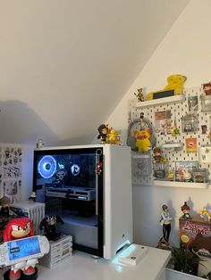 a room filled with lots of toys and clutter on top of a white desk