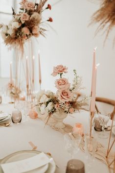 the table is set with flowers and candles