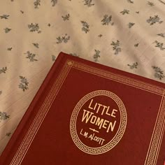 a little women book sitting on top of a bed