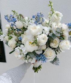 a bouquet of white and blue flowers in a vase