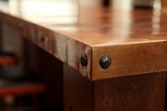 a close up view of a wooden table with metal rivets