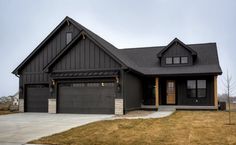 a black house with two garages on the front