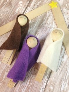 three wooden peg dolls are sitting on a table