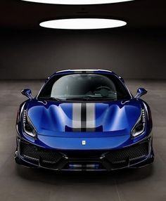 a blue sports car in a dark room with white stripes on the front and side