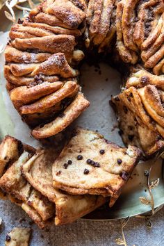 a cake that has been sliced into pieces and is on a plate with other pastries around it