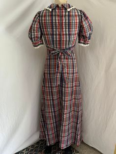 1960s madras plaid prairie maxi dress. Love the silhouette on this dress! Puffed sleeves, wide waistband into an a-line skirt. Big collar with lace trim detailing. Attached waist tie. Center back metal zip. No tags. Cotton. Excellent condition. Washed and ready to wear.  MEASUREMENTS(taken flat, double when appropriate) PTP 17 Underbust 15 Waist 13 1/2 Hips 20 Length 55 This is the perfect unique gift for a loved one, or yourself! Please be sure to email all questions before purchasing, as I do not take returns. As always, I am here to answer questions, so just send me a message! New creations and finds are always being added. Check back soon! Follow me on Instagram @movingmamasvintage http://www.etsy.com/shop/movingmamasvintage  Love and light🌸 Summer Cotton A-line Vintage Dress, Retro Cotton Lined Dresses, Summer Retro Cotton Vintage Dress, Lined Cotton Vintage Short Sleeve Dress, Retro Cotton Maxi Dress, 1970s Style Cotton Summer Dress, Multicolor 1970s Summer Dresses, 1970s Cotton Vintage Dress For Daywear, 1970s Style Sleeveless Cotton Dress