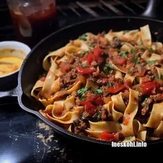 a skillet filled with pasta and meat sauce