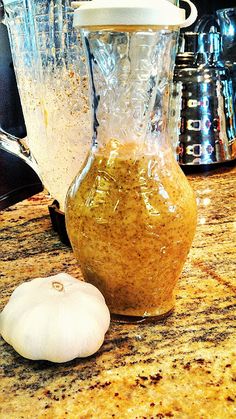 garlic and seasoning in a blender on a counter next to other kitchen appliances