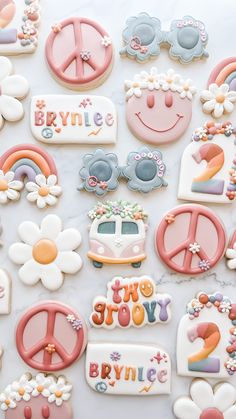 decorated cookies are arranged on a table with flowers and peace signs in the middle,