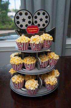 three tiered trays filled with cupcakes and popcorn