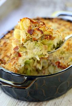 a casserole dish with broccoli and cheese being lifted from the casserole