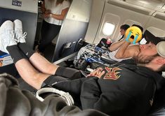 a man sleeping on an airplane with his feet up and headphones in his ears