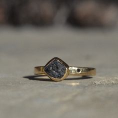 a close up of a gold ring with a black diamond