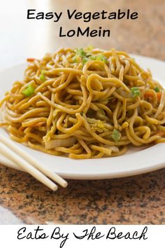 an easy vegetable lo mein recipe on a white plate with chopsticks next to it