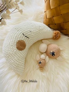 a crocheted stuffed animal laying on top of white fur