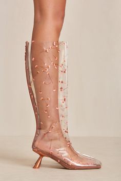 An Italian vinyl boot with real pressed flowers accentuated by a satin toe cap and satin heel. — Italian vinyl — Real pressed flowers — Satin toe cap, footbed, and heel — Zip opening Clear Boots, Icon Clothing, Evening Flats, Sandal Platform, Swimming Bag, Satin Heels, Candle Collection, Cult Gaia, Kids Sandals