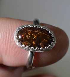 This beautiful fire agate silver ring has a stone that hails from Mexico. This fire agate has a galaxy of fire in orange and even a bit of green. We handcrafted both the stone and the silver ring setting for this piece. This is an adjustable ring with a split shank. The ring is at about a size 7. It can be worn in the range of 6.5 to 8 comfortably. If you have a size in mind let us know and we'll set it to that before shipping it out. You can then adjust the split band as needed from there. This Fire Agate Jewelry, Fire Agate Ring, Silver Ring Set, Manufactured Stone, Fire Agate, Agate Jewelry, Small Containers, Ring Setting, Agate Ring