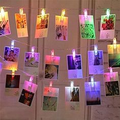 many pictures are hung on a string with lights