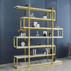 a modern shelving unit with bookshelves and vases on it, against a blue wall