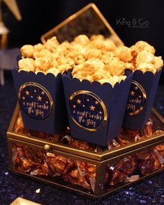 three blue boxes filled with popcorn sitting on top of a table