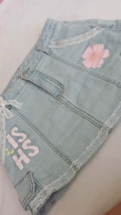 a pair of jean shorts with flowers on them