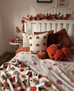 a bed with pumpkins and other fall decorations on the headboard, along with a teddy bear