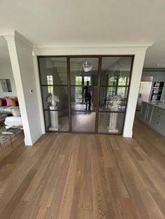 an empty living room with wood floors and glass doors