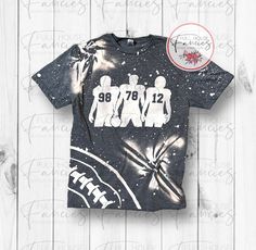 This super cute bleached football tee is perfect to show support for your three favorite players. This tee features a large football, three football players with your chosen numbers and bleached splatters. Tee has the football and players on the front only. The back has bleach splatters. Please add the numbers of your choice in the personalization field when ordering.  If you would like to customize this tee...such as having a name added to the back of the shirt, you will need to purchase the custom upcharge listing. Please contact me before ordering if you would like to customize this tee. There are two choices of shirts: Gildan (G) Softstyles - 65% poly/35% cotton Bella Canvas (BC) Heathers - 52% cotton/48% poly Color swatches are only a guide and for general color choices only, as color Football Outline, Team Spirit Shirts, Custom Football Shirts, Shell Knob, Football Ideas, Sport Theme, Sticker Design Inspiration, Sports Mom Shirts, Bleached Shirt