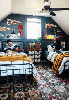 two people are sitting on their beds in the attic bedroom with colorful rugs and wall decorations