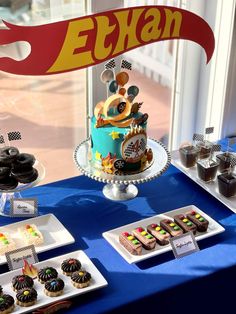 a table topped with cakes and desserts next to a window