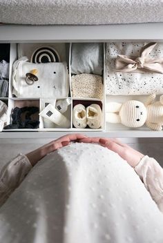 a woman is sitting in front of a drawer full of items