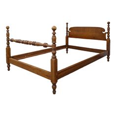 an antique wooden bed frame with turned posts and headboard, isolated against a white background