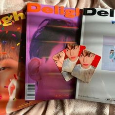 three magazines laying on top of a bed next to each other, one with the cover pulled down