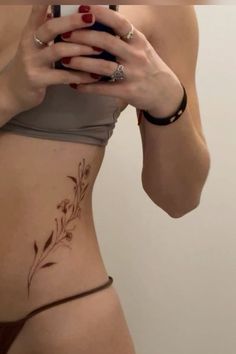 a woman with tattoos on her stomach taking a selfie