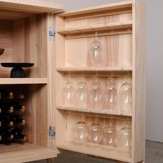 a wooden cabinet filled with wine glasses and bottles