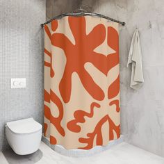 an orange and white shower curtain in a bathroom with a toilet next to the wall