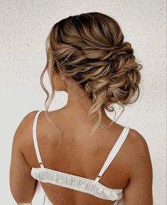 a woman with her back turned to the camera, wearing a white dress and braided hair