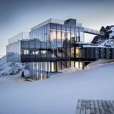 a glass building on top of a snow covered mountain with stairs leading up to it