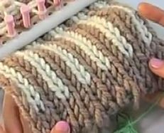 a close up view of a knitted blanket with white and brown stripes on it