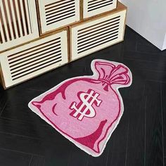 a pink bag with a dollar sign on it sitting in front of a wooden cabinet