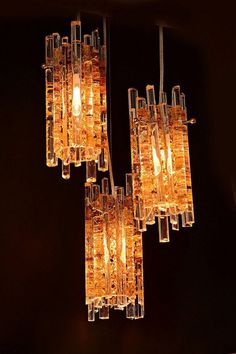 a chandelier made out of glass blocks hanging from the ceiling in a dark room