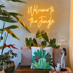 there is a neon sign that says welcome to the jungle on the wall next to some potted plants